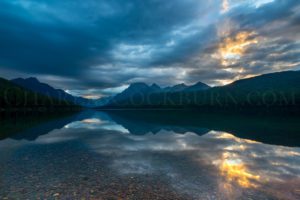 The sun rises at the start of the day over Bowman Lake, Glacier National Park